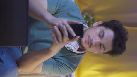 Vertical-video-of-Depressed-man-at-night-texting-on-the-phone.